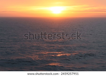 Dawn at sea, with waves tinged with golden sunlight Royalty-Free Stock Photo #2459257951