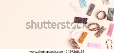 Banner with handcrafted beaded rings on a beige background. Creative concept with place for text.