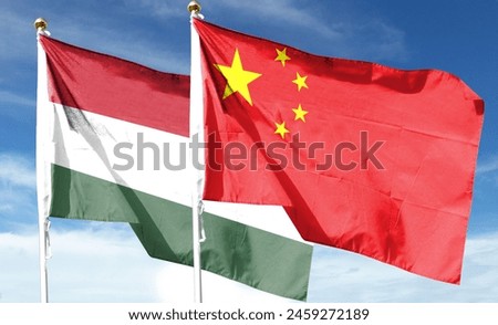 There are Chinese and Hungarian flags on the cloudy sky. fly in the sky