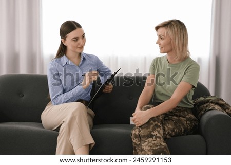 Psychotherapist working with military woman on sofa in office