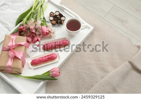 Tasty breakfast served in bed. Delicious desserts, tea, flowers, gift box and card with phrase I Love You on tray, above view. Space for text