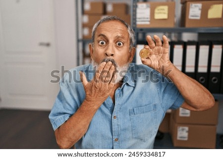 Shocked senior man covers mouth in surprised fear at office, silent with cryptocurrency bitcoin coin mistake Royalty-Free Stock Photo #2459334817