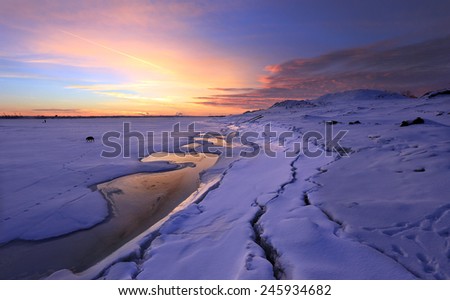 winter landscape beautiful sunset over the river covered with ice and the city on the horizon 