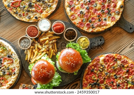 Top View picture: A variety of burgers pizaa and fries