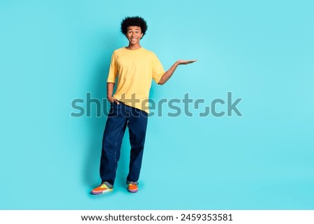 Full size photo of crazy impressed man wear oversize t-shirt palm presenting product empty space isolated on teal color background