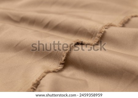 Mauled khaki-colored fabric texture background. This fabric is made of polyester and spandex. Royalty-Free Stock Photo #2459358959