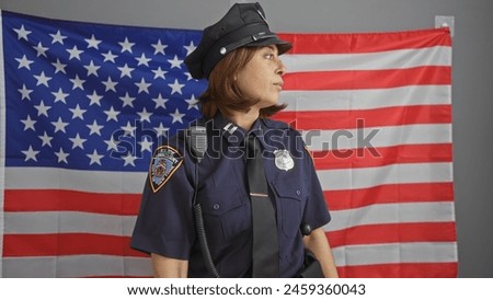 Mature hispanic policewoman in uniform stands before an american flag, symbolizing law enforcement in the usa. Royalty-Free Stock Photo #2459360043