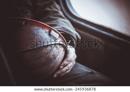 durty hands of miner worker hold helmet no face  Royalty-Free Stock Photo #245936878