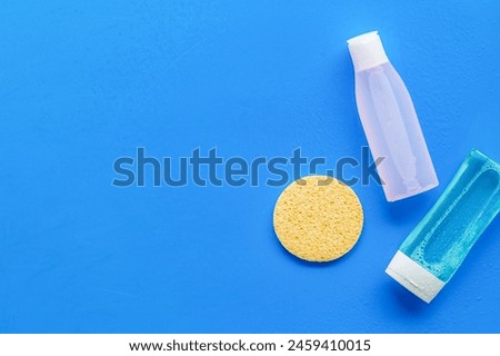 Face cleaning. Organic cosmetics. Mycelial water , lotion and sponge for skin care on blue background flat lay space for text Royalty-Free Stock Photo #2459410015