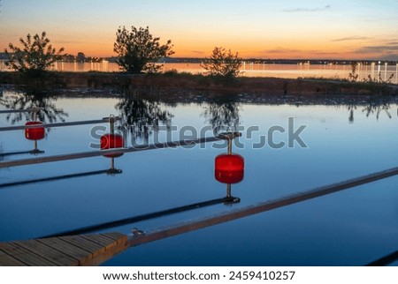 Empty marina on the lake after sunset, red buoys Royalty-Free Stock Photo #2459410257