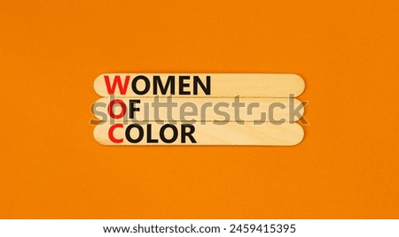 WOC women of color symbol. Concept words WOC women of color on beautiful wooden stick. Beautiful orange background. Business WOC women of color social issues concept. Copy space. Royalty-Free Stock Photo #2459415395
