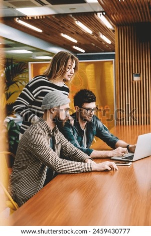 Group of skilled men and creative woman watching training webinar in website on laptop computer connected to wireless internet.Talented hipster guys solving startup issues using modern technology