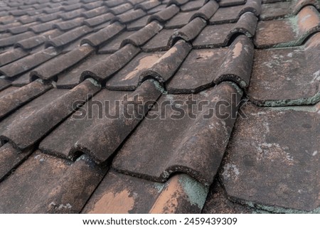 background of worn and mossy red tiles, moss-covered house roofs, tiled roofs.