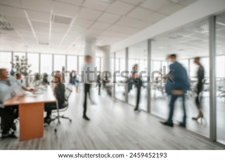 business people walking in the corridor of an business center, pronounced motion blur, crowded bright modern light office movement defocused. office background busy. talking and rushing in the lobby. Royalty-Free Stock Photo #2459452193