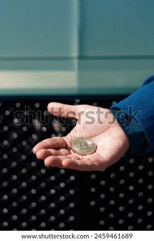 Man's hand holds a gold coin bitcoin coin. BTC golden money