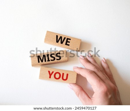We Miss you symbol. Concept words We Miss you on wooden blocks. Beautiful white background. Man hand. Emotion and We Miss you concept. Copy space.