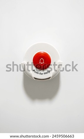 Vertical format photo of an emergency button in a hospital. the background is white