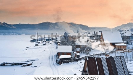 The serene winter landscape, with snow-covered houses and smoke rising from chimneys, creates a cozy, chilly atmosphere. Royalty-Free Stock Photo #2459542297