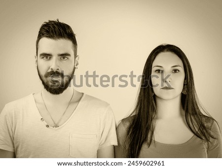 Man and woman pose with grave expressions, their serious demeanor suggesting a moment of deep contemplation In a copy of the typical 19th century photo