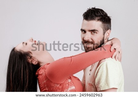 Euphoric scene where a man and woman share a joyful embrace, highlighted by their bright casual clothing and warm, heartfelt expressions Royalty-Free Stock Photo #2459602963