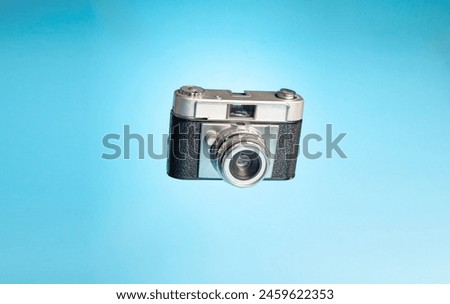 Vintage camera on a light blue background. Photography day concept