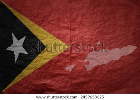 colorful big national flag and map of east timor on a grunge old paper texture background
