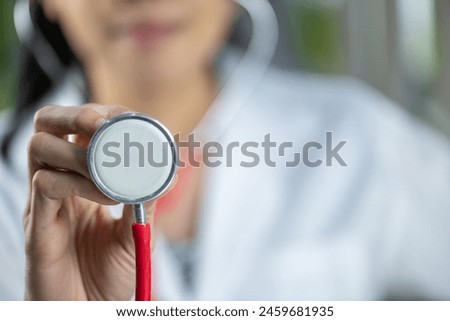 A close-up of a female doctor holding a stethoscope.