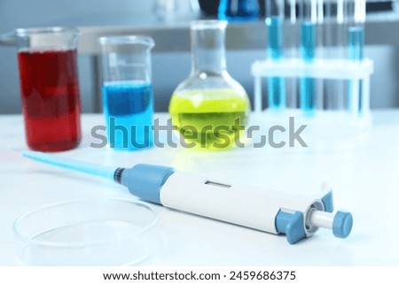 Laboratory analysis. Micropipette, petri dish and other glassware on white marble table, closeup