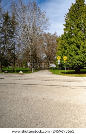 Road in the park with signs for pedestrians and cyclists on a sunny day