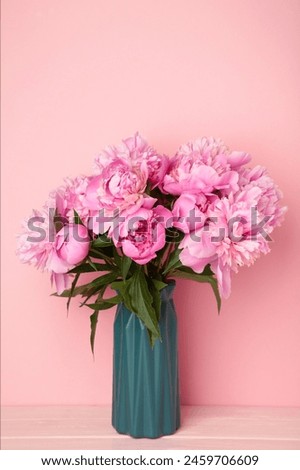 Vase with beautiful peonies on pink background. Vertical photo