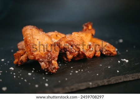 Chicken wings on black background Royalty-Free Stock Photo #2459708297