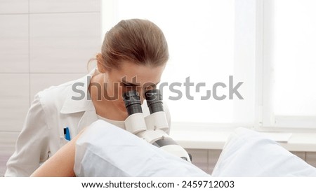 Gynecological office in a modern clinic. The gynecologist uses a colposcope and takes tests from the patient. A woman lies on a gynecological chair during a colposcopy. Preparing for pregnancy.