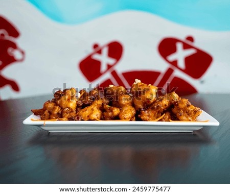 Delectable Gobi Manchurian served on a modern plate, featuring crispy cauliflower in a tangy sauce Royalty-Free Stock Photo #2459775477