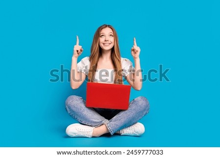 Full size photo of nice young girl direct fingers up empty space wear top isolated on blue color background
