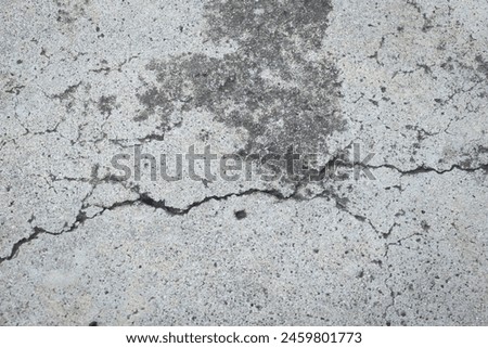 Large textured floor cracked, scratched, stained, with small holes, broken, damaged, asphalt, cement, gray. Royalty-Free Stock Photo #2459801773