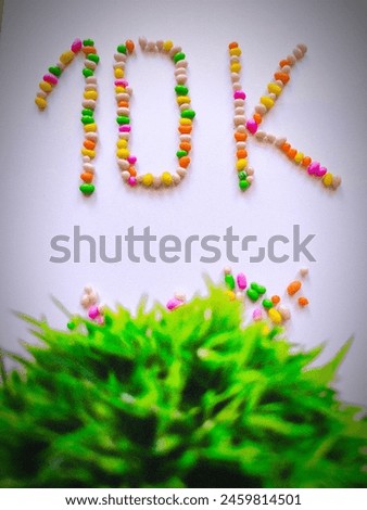 Multicolour 10k alphabet written picture. Multicolour 10k with grass picture isolated on white background. Negative space is available in the centre of the picture 