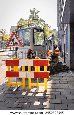 Excavator heavy duty machinery repairing the pavement in a city centre. Working sign and digging up soil from the sidewalk, roadwork repair with equipment in The Netherlands, vertical