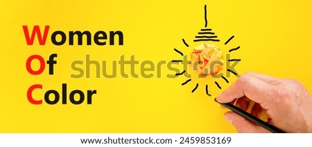 WOC women of color symbol. Concept words WOC women of color on beautiful yellow paper. Beautiful yellow background. Businessman hand. Business WOC women of color social issues concept. Copy space. Royalty-Free Stock Photo #2459853169