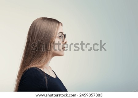 Side-view portrait of a contemplative young female, her expression serene and focused outward
