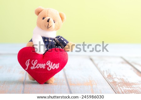 Teddy Bear with Red Heart on wooden table for valentine day