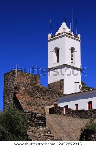 The Clock Tower and stone battlements. The historic, fortified town of Monsaraz, built within medieval defensive walls. Evora, Alentejo Region, Portugal. Royalty-Free Stock Photo #2459892815