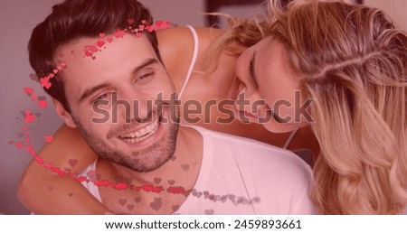 Image of red hearts over couple in love embracing and smiling. Valentine's day, love and romance concept digitally generated image.
