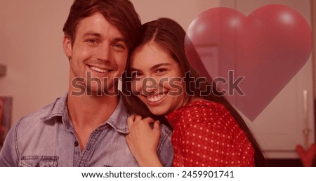 Image of red heart over couple in love smiling. Valentine's day, love and romance concept digitally generated image.