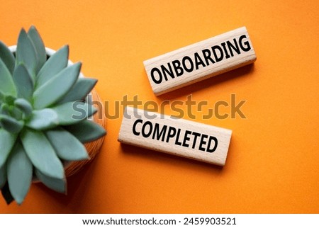 Onboarding Completed symbol. Concept word Onboarding Completed on wooden blocks. Beautiful orange background with succulent plant. Business and Onboarding Completed concept. Copy space