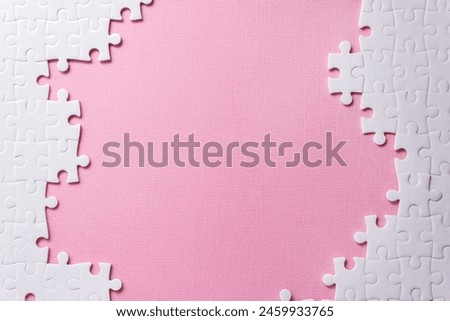 Frame of white puzzle elements on pink background. Concept for beauty industry. Selective focus, copy space Royalty-Free Stock Photo #2459933765