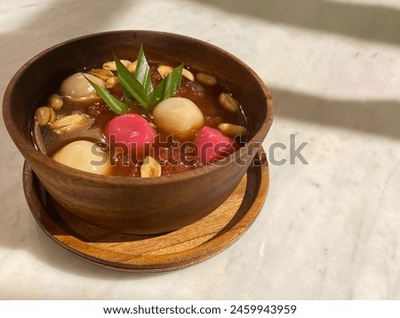 wedang ronde in a wooden bowl, one of the typical drinks of Central Java. This drink contains a slightly spicy concoction with small round snacks in it. Royalty-Free Stock Photo #2459943959