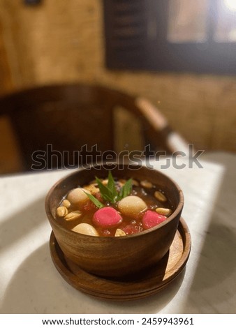 wedang ronde in a wooden bowl, one of the typical drinks of Central Java. This drink contains a slightly spicy concoction with small round snacks in it. Royalty-Free Stock Photo #2459943961