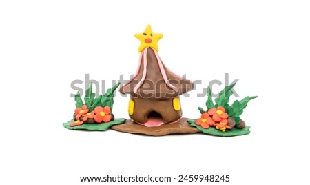 plasticise molded into nature of a storybook house decorated with small flower bushes isolated on a white background, handmade plasticine.