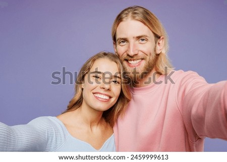 Close up young couple two friends family man woman wear pink blue casual clothes together doing selfie shot pov on mobile cell phone isolated on pastel plain light purple background studio portrait
