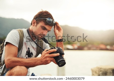 Man, camera and travel photographer at mountain as photo journalist for tourism, hobby or water. Male person, pictures and outdoor creative at sea in Australia or blog equipment, view or professional